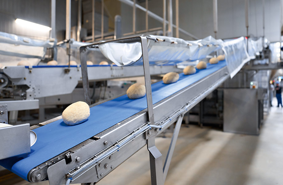 Bread dough moving along a conveyor belt. If systems go down, this also brings the lorries to a standstill, and no bread can be delivered.
